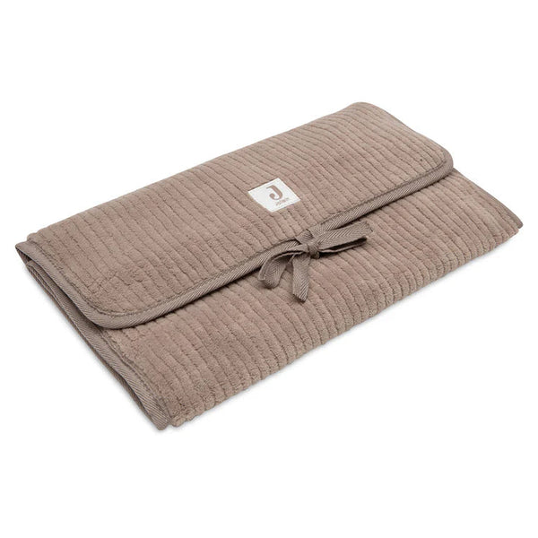 Tapis à langer nomade en tissu côtelé taupe avec intérieur feuillage. Léger, pliable et pratique avec poches intégrées. Idéal pour les sorties avec bébé.