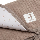 Tapis à langer nomade en tissu côtelé taupe avec intérieur feuillage. Léger, pliable et pratique avec poches intégrées. Idéal pour les sorties avec bébé.