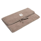 Tapis à langer nomade en tissu côtelé taupe avec intérieur feuillage. Léger, pliable et pratique avec poches intégrées. Idéal pour les sorties avec bébé.