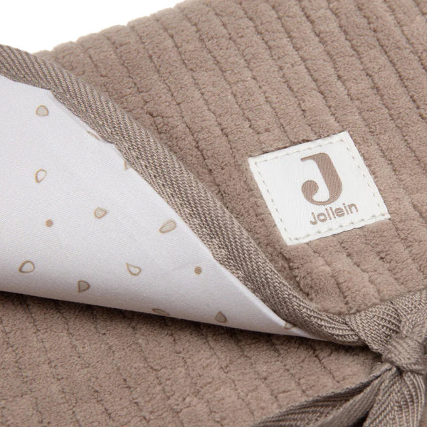 Tapis à langer nomade en tissu côtelé taupe avec intérieur feuillage. Léger, pliable et pratique avec poches intégrées. Idéal pour les sorties avec bébé.