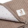 Tapis à langer nomade en tissu côtelé taupe avec intérieur feuillage. Léger, pliable et pratique avec poches intégrées. Idéal pour les sorties avec bébé.