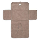 Tapis à langer nomade en tissu côtelé taupe avec intérieur feuillage. Léger, pliable et pratique avec poches intégrées. Idéal pour les sorties avec bébé.