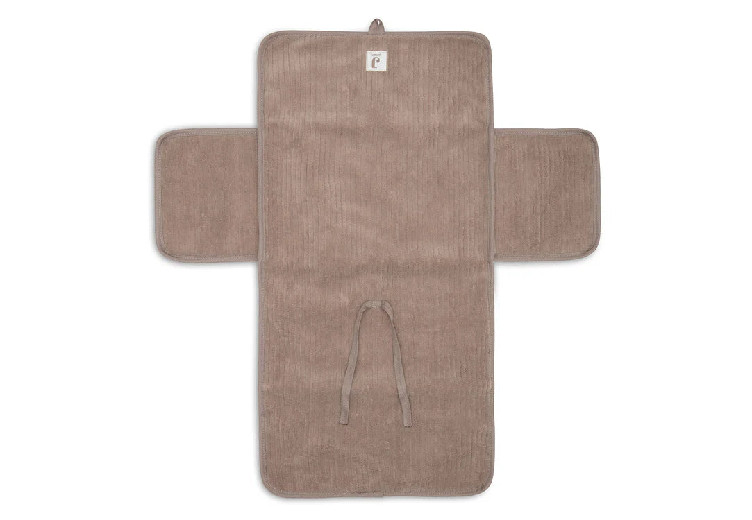 Tapis à langer nomade en tissu côtelé taupe avec intérieur feuillage. Léger, pliable et pratique avec poches intégrées. Idéal pour les sorties avec bébé.