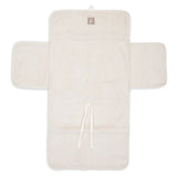 Tapis à langer nomade en tissu côtelé beige avec intérieur feuillage. Léger, pliable et pratique avec poches intégrées. Idéal pour les sorties avec bébé.