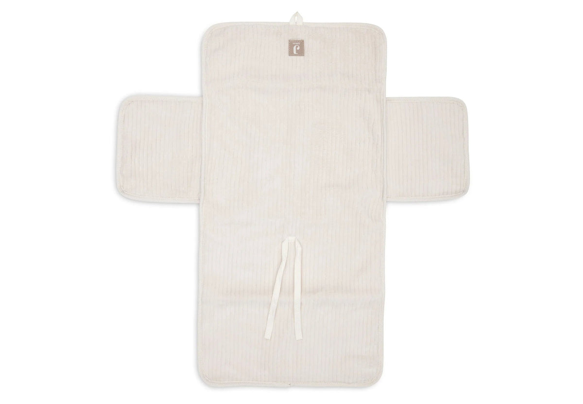 Tapis à langer nomade en tissu côtelé beige avec intérieur feuillage. Léger, pliable et pratique avec poches intégrées. Idéal pour les sorties avec bébé.