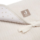 Tapis à langer nomade en tissu côtelé beige avec intérieur feuillage. Léger, pliable et pratique avec poches intégrées. Idéal pour les sorties avec bébé.