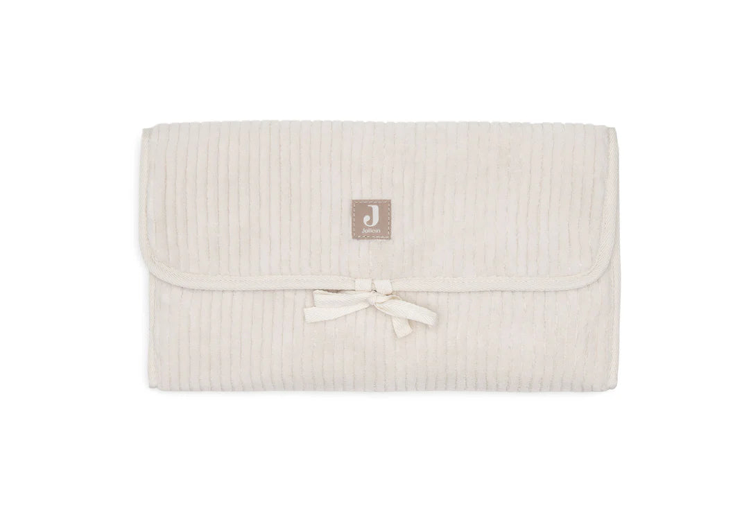 Tapis à langer nomade en tissu côtelé beige avec intérieur feuillage. Léger, pliable et pratique avec poches intégrées. Idéal pour les sorties avec bébé.