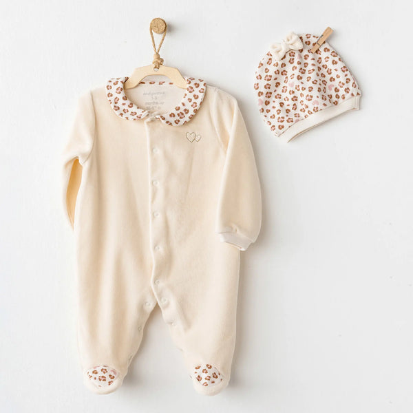 Pyjama velours beige pour bébé avec liserés léopard et bonnet assorti. Ouverture à pressions pour un habillage facile. Confort et style pour les premiers mois.