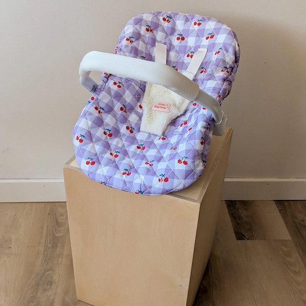 Coquille Tiny Harlow Vichy lilas et cerise pour transporter votre poupée partout. Poignée, sangles sécurisées et housse amovible lavable. Jouet d’imitation pour enfants dès 3 ans.