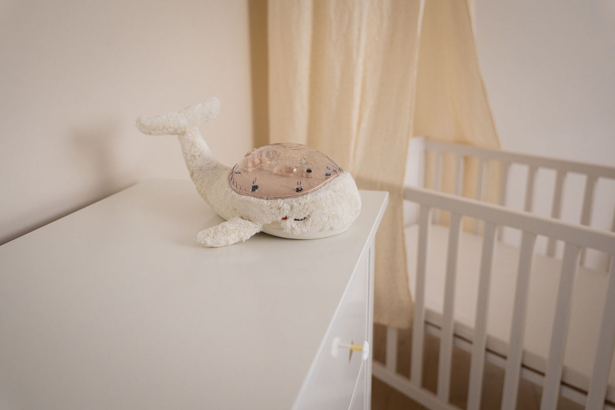 Veilleuse bébé Tranquil Whale™ blanche rechargeable : projections océaniques, bruits blancs, capteur de pleurs et minuterie. Idéale dès la naissance et parfaite en cadeau de naissance.