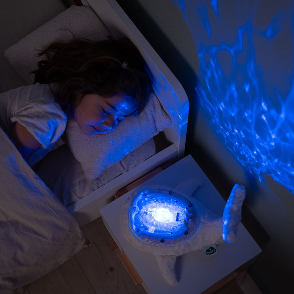 Veilleuse bébé Tranquil Whale™ blanche rechargeable : projections océaniques, bruits blancs, capteur de pleurs et minuterie. Idéale dès la naissance et parfaite en cadeau de naissance.