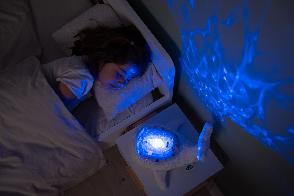 Veilleuse bébé Tranquil Whale™ blanche rechargeable : projections océaniques, bruits blancs, capteur de pleurs et minuterie. Idéale dès la naissance et parfaite en cadeau de naissance.