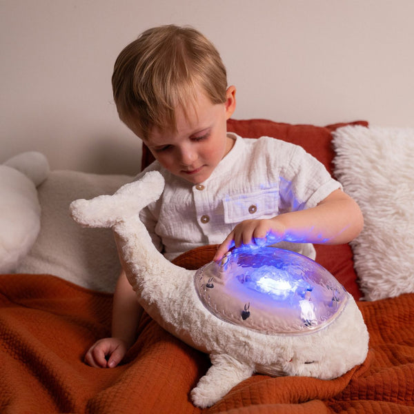 Veilleuse bébé Tranquil Whale™ blanche rechargeable : projections océaniques, bruits blancs, capteur de pleurs et minuterie. Idéale dès la naissance et parfaite en cadeau de naissance.
