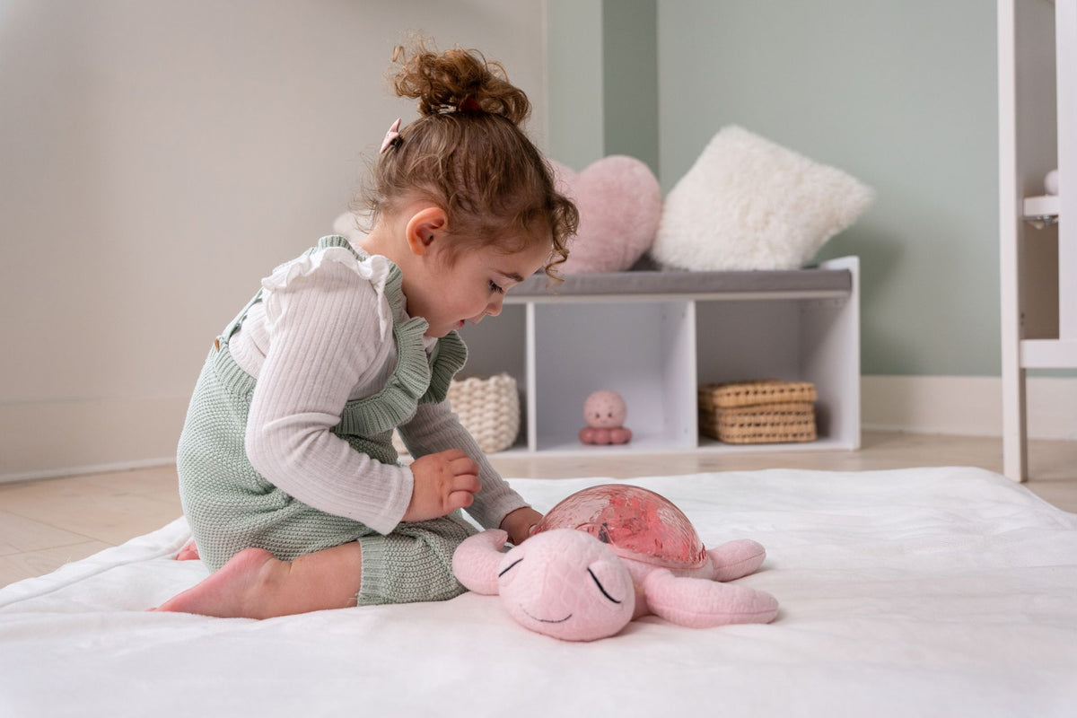 Veilleuse bébé Tranquil Turtle™ rose rechargeable : projections océaniques, bruits blancs, capteur de pleurs et minuterie. Idéale dès la naissance et parfaite en cadeau de naissance.