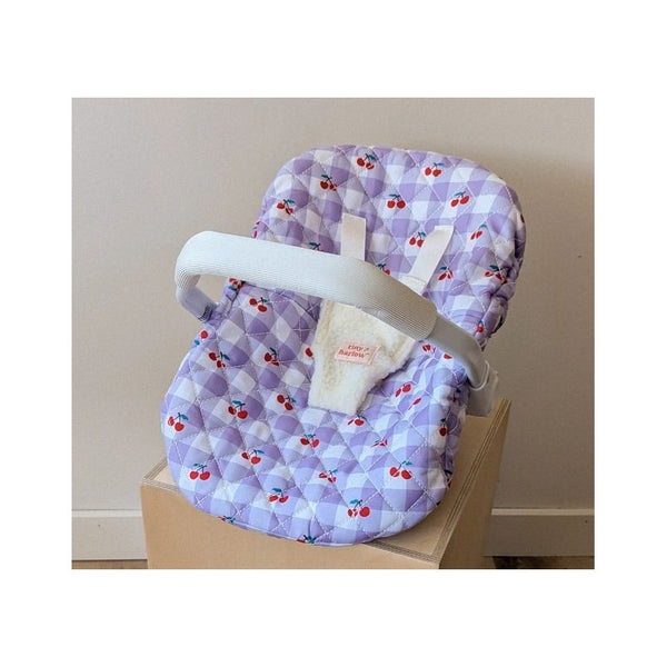 Coquille Tiny Harlow Vichy lilas et cerise pour transporter votre poupée partout. Poignée, sangles sécurisées et housse amovible lavable. Jouet d’imitation pour enfants dès 3 ans.