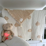 Couverture bébé en mousseline de coton avec motif nuage beige en relief. Douce, respirante et idéale dès la naissance. Indispensable des listes de naissance.