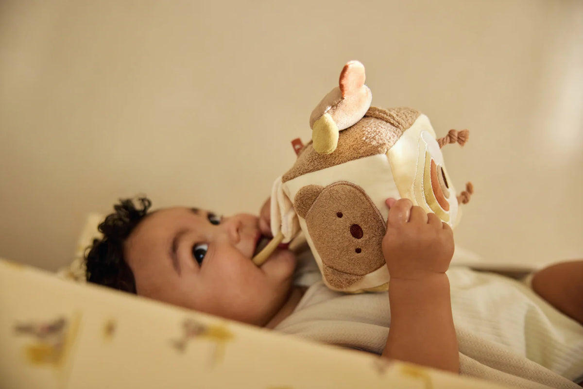 Cube d’activités bébé Kangourou avec miroir, grelots, tissu qui craque et figurines d’animaux. Stimule la motricité, l’éveil sensoriel et le jeu interactif.