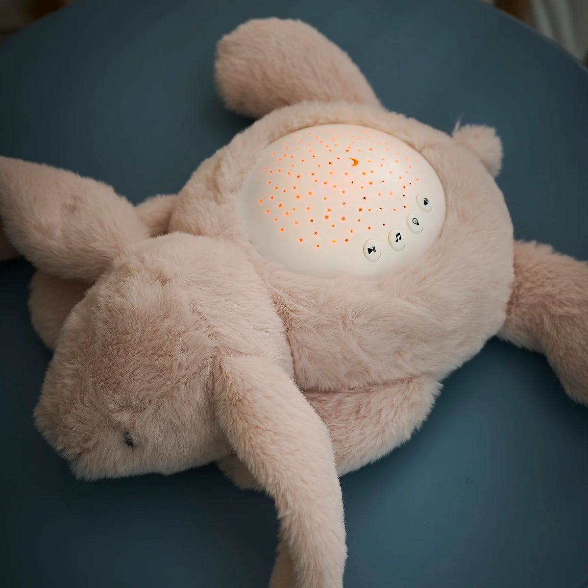 Veilleuse peluche bébé avec projection d’étoiles et sons apaisants. Lumière douce, timer 20 min, parfait pour endormir bébé en toute sécurité.