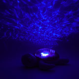 Veilleuse bébé Tranquil Turtle™ rose rechargeable : projections océaniques, bruits blancs, capteur de pleurs et minuterie. Idéale dès la naissance et parfaite en cadeau de naissance.
